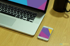 Smartphone Mockup Next to Laptop on Wooden Desk