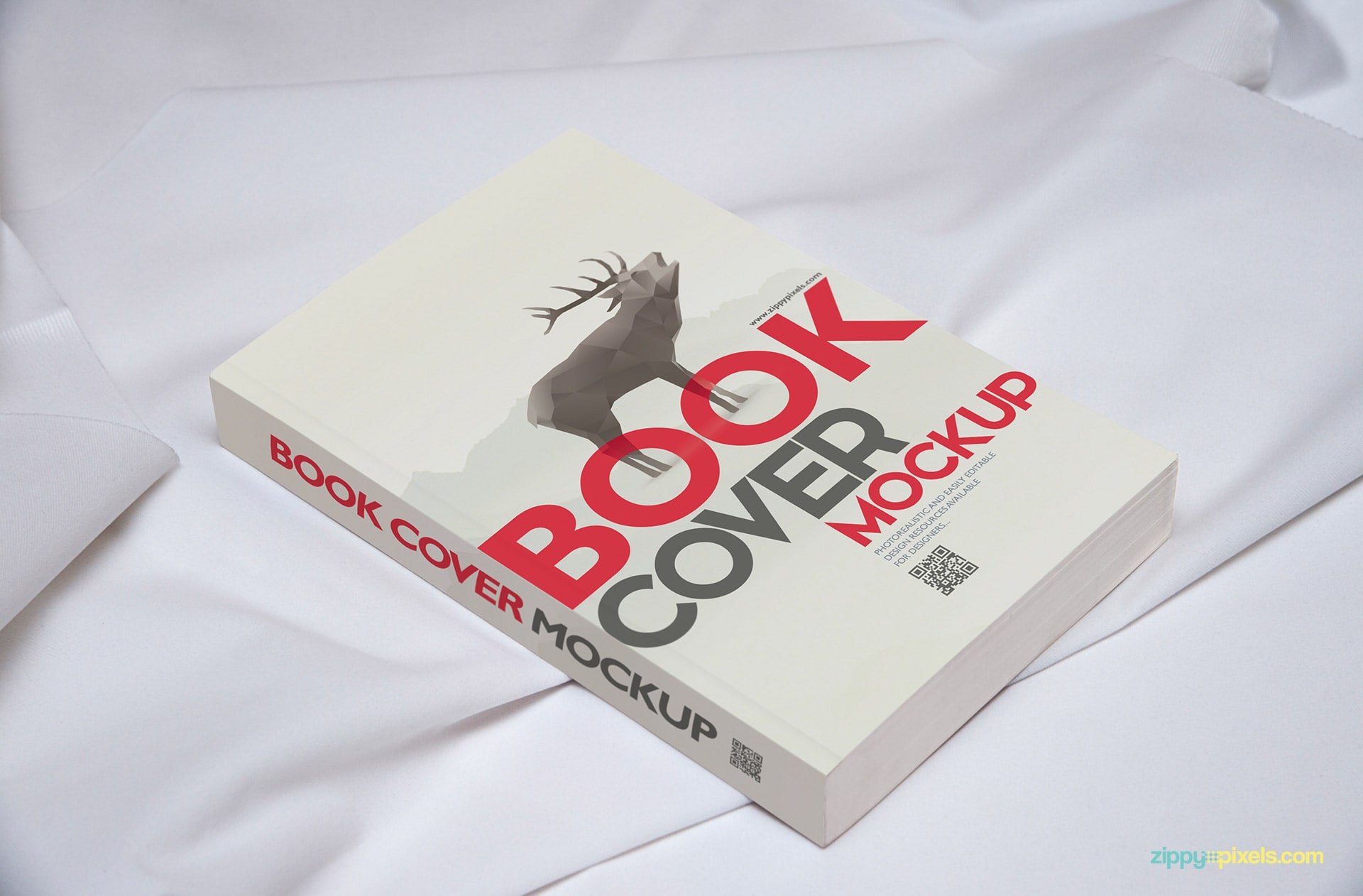 Book cover mockup showing paperback book laying on white clothe